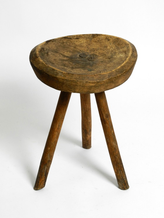 Image 1 of Magnifique tabouret à trois pieds en bois massif sculpté à la main dans les années 1900, avec une patine fantastique.