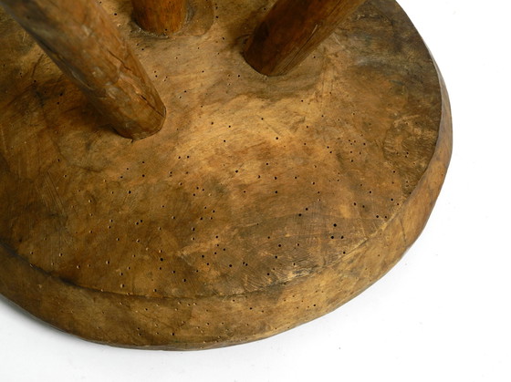 Image 1 of Magnifique tabouret à trois pieds en bois massif sculpté à la main dans les années 1900, avec une patine fantastique.