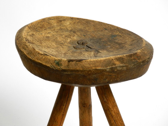 Image 1 of Magnifique tabouret à trois pieds en bois massif sculpté à la main dans les années 1900, avec une patine fantastique.