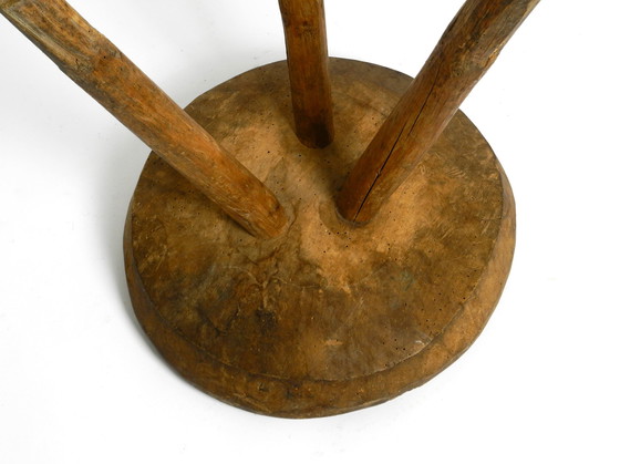 Image 1 of Magnifique tabouret à trois pieds en bois massif sculpté à la main dans les années 1900, avec une patine fantastique.