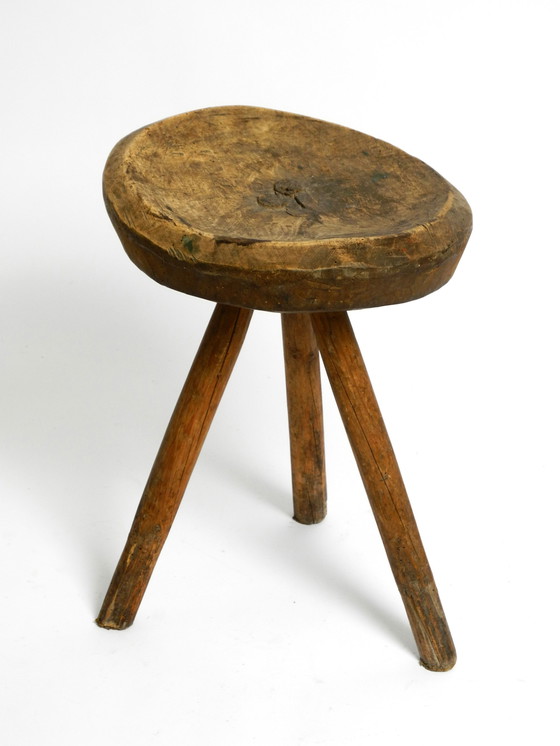 Image 1 of Magnifique tabouret à trois pieds en bois massif sculpté à la main dans les années 1900, avec une patine fantastique.