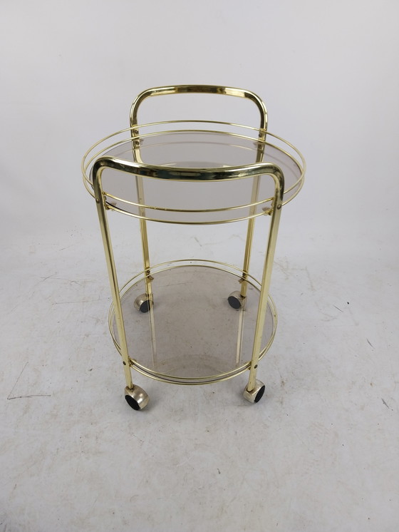 Image 1 of 1 x gold plated beverage trolley 1970's. Smoke glass