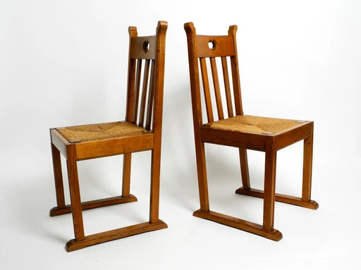 A pair of Mid Century oak chairs with skid feet and wicker seats