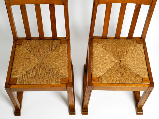 Image 1 of A pair of Mid Century oak chairs with skid feet and wicker seats