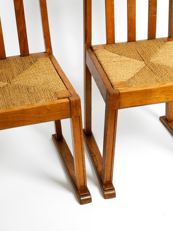 Image 1 of A pair of Mid Century oak chairs with skid feet and wicker seats