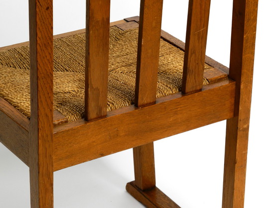 Image 1 of A pair of Mid Century oak chairs with skid feet and wicker seats