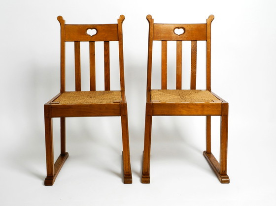 Image 1 of A pair of Mid Century oak chairs with skid feet and wicker seats