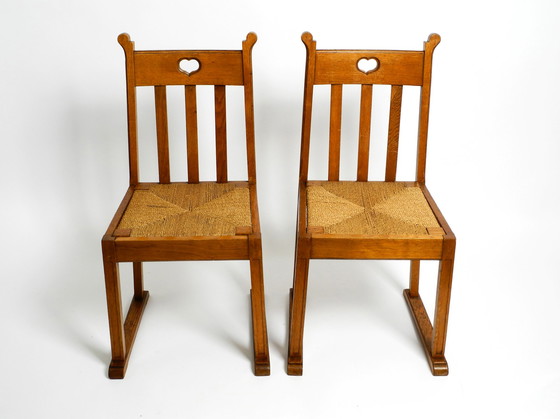 Image 1 of A pair of Mid Century oak chairs with skid feet and wicker seats