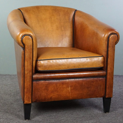 Fauteuil club en cuir de mouton clair avec passepoil noir