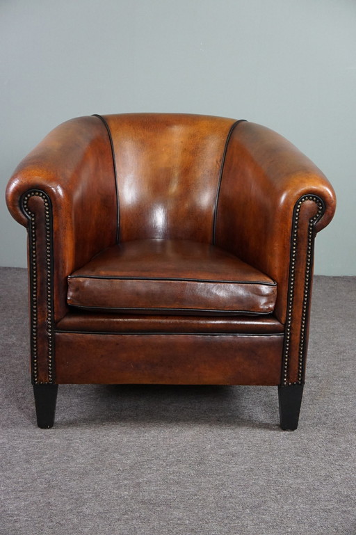 Club armchair with black piping and decorative nails