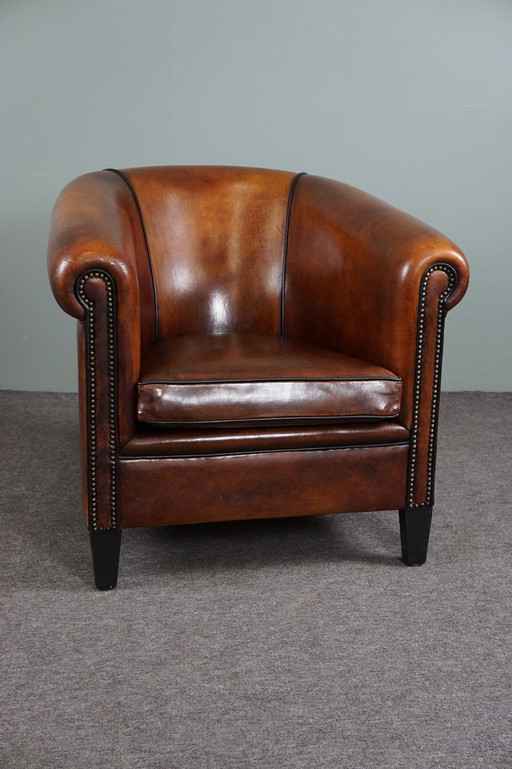 Club armchair with black piping and decorative nails