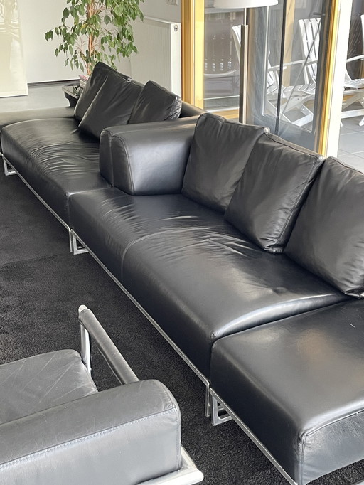 2x canapés B&B Italia en cuir noir avec 2x poufs et table d'appoint