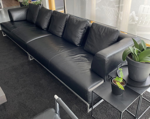 2x canapés B&B Italia en cuir noir avec 2x poufs et table d'appoint