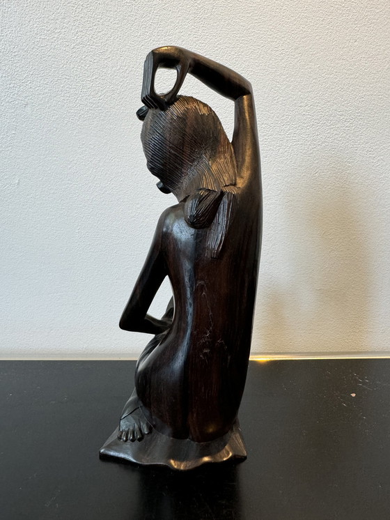 Image 1 of Sculpture en bois dans un miroir regardant une femme