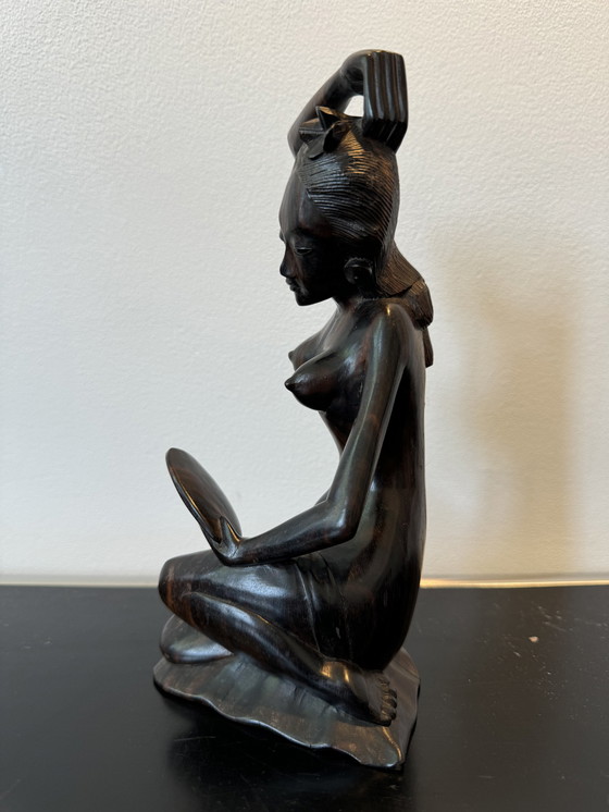 Image 1 of Sculpture en bois dans un miroir regardant une femme