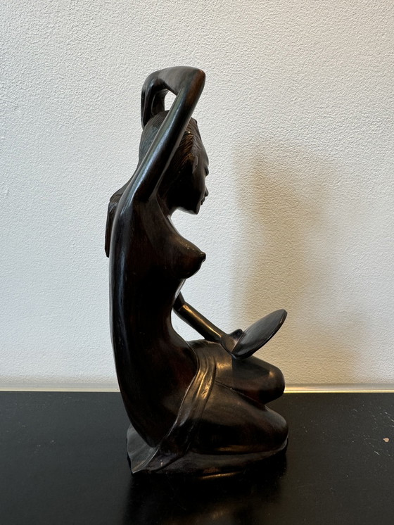 Image 1 of Sculpture en bois dans un miroir regardant une femme