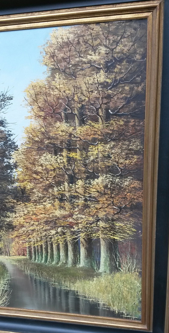 Image 1 of Oil painting with a row of trees on the water signed Verkerk