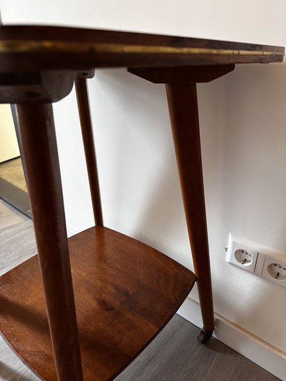 Image 1 of Side table with brass on wheels