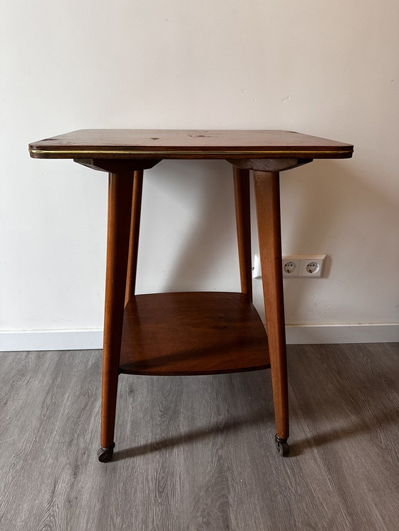 Image 1 of Side table with brass on wheels