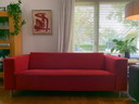Sofá Jamé Design con puf rojo