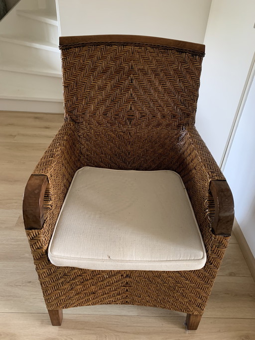 Un magnifique fauteuil en rotin avec un coussin de couleur écru