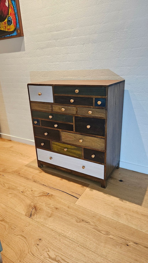 Belle commode avec tiroirs multicolores.