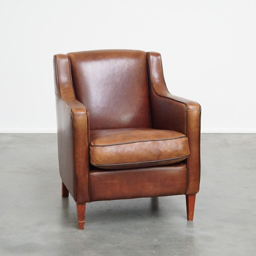 Fauteuil en peau de mouton avec passepoil marron foncé