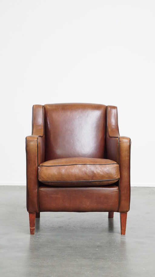 Fauteuil en peau de mouton avec passepoil marron foncé