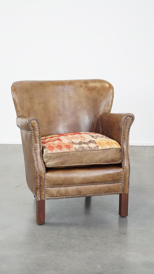 Fauteuil en cuir de boeuf avec coussin d'assise réversible en kelim