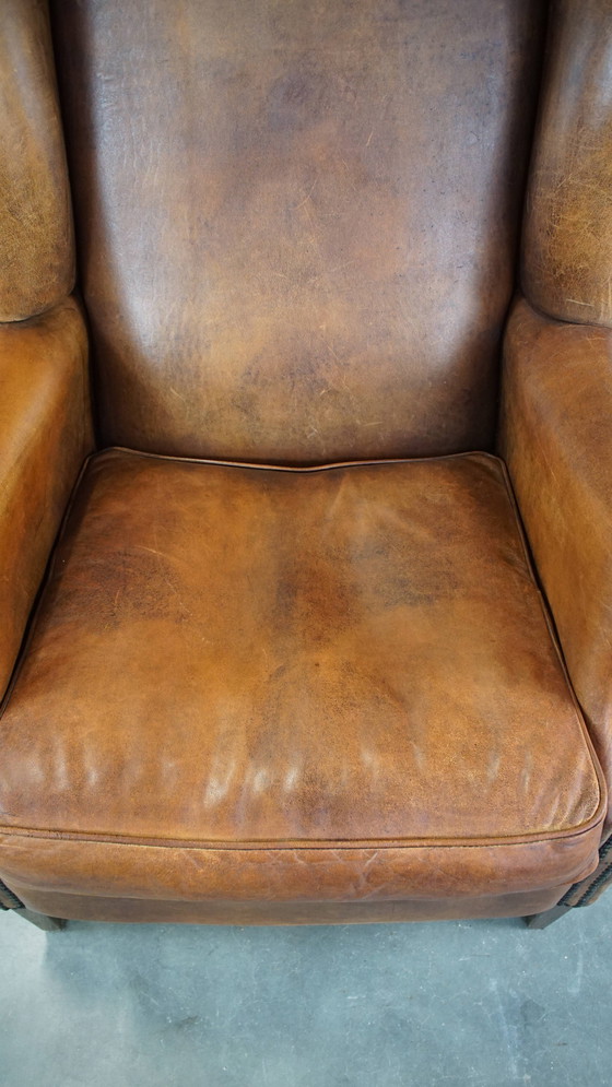 Image 1 of Grand fauteuil à oreilles en cuir de mouton avec clous ornementaux
