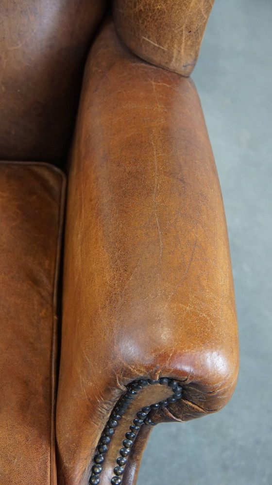 Image 1 of Grand fauteuil à oreilles en cuir de mouton avec clous ornementaux