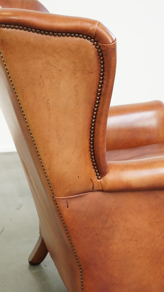 Image 1 of Fauteuil à oreilles en cuir lisse avec clous décoratifs