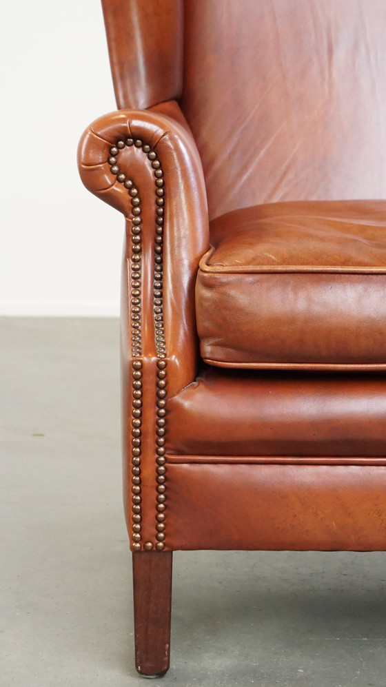 Image 1 of Fauteuil à oreilles en cuir lisse avec clous décoratifs