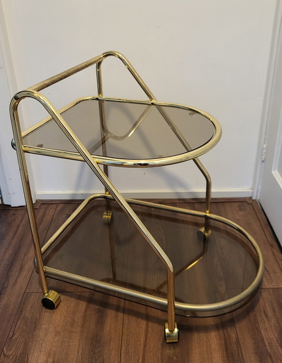 Image 1 of Chariot de bar vintage Hollywood Regency en laiton et verre fumé.