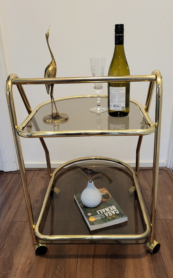 Image 1 of Chariot de bar vintage Hollywood Regency en laiton et verre fumé.