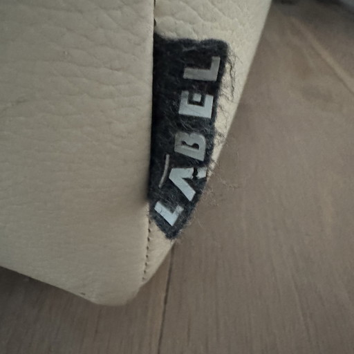 Cremefarbener Ledersessel mit Fußhocker