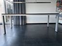 Arco mit Holzplatte und Aluminiumbeinen.